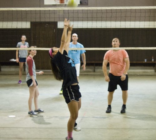 A group of young adults playing volleyball.