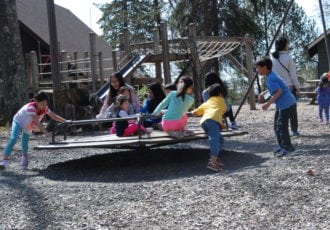 Kids on a playground carousel.