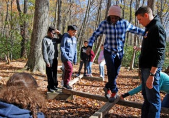 Kids on a balance beam.