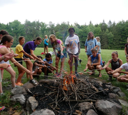Roasting food over a campfire.