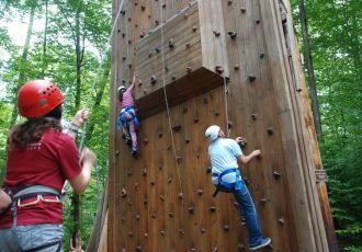 Man climbing up climbing wall.